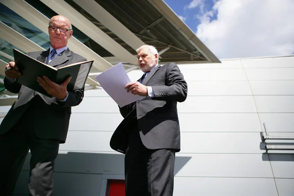Hauts hommes d'affaires lisant des documents à l'extérieur — Photo