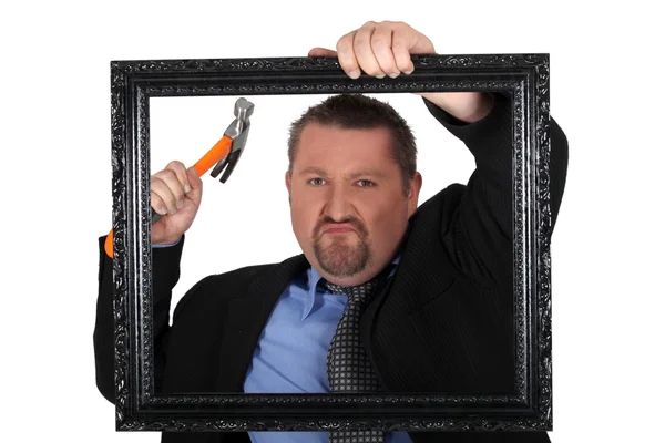 Businessman with a hammer and frame — Stock Photo, Image