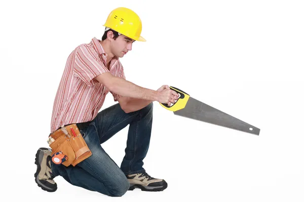 Young carpenter in profile stretching saw — Stock Photo, Image