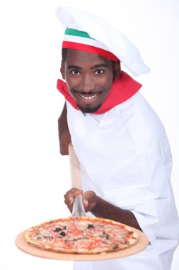 Man serving a pizza on a wooden peel (board) clipart