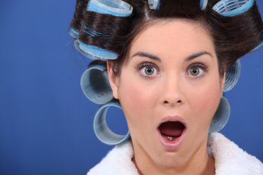 Surprised woman with her hair in rollers clipart