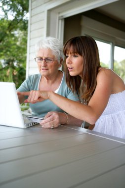 A grandmother and her granddaughter doing computer clipart