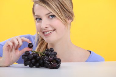 Blonde woman showing grapes clipart