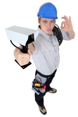 Electrician installing a surveillance camera clipart