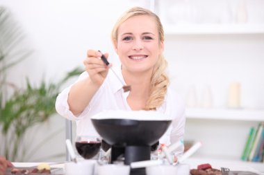 Woman having a fondue bourguignonne clipart