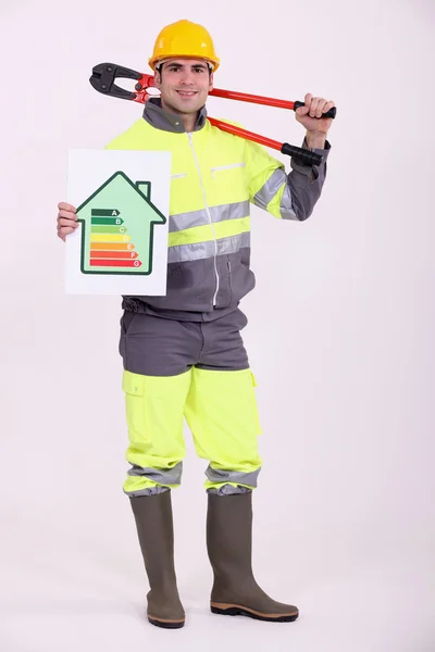 Tradesman holding large clippers and an energy efficiency rating chart — Stock Photo, Image