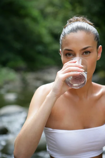 Bruneta pít sklenici vody — Stock fotografie