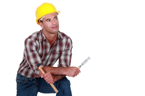 A dreamy tradesman holding a hammer and chisel — Stock Photo, Image