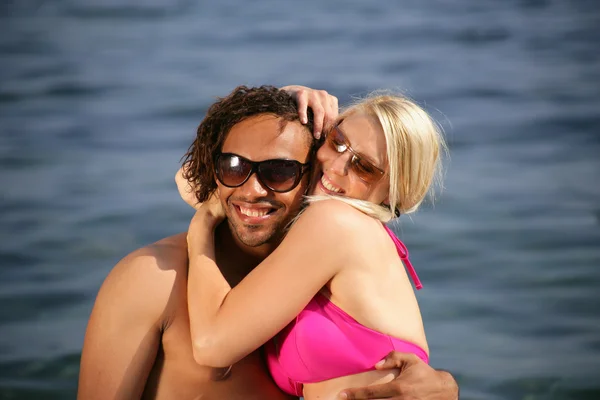 Interracial par på stranden — Stockfoto