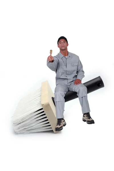 Housepainter sitting on large size paintbrush — Stock Photo, Image