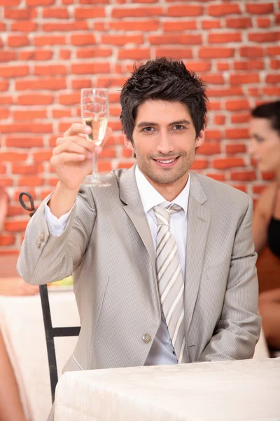 Homme levant une coupe de champagne — Photo
