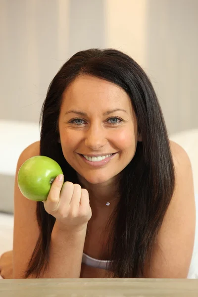 Портрет женщины, держащей яблоко — стоковое фото