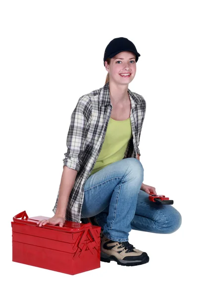 Mujer arrodillada por kit de herramientas —  Fotos de Stock