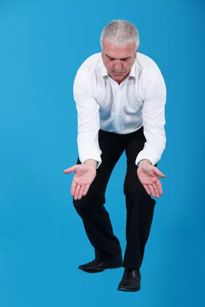 Affärsman knä och hålla sina händer vidöppen — Stockfoto