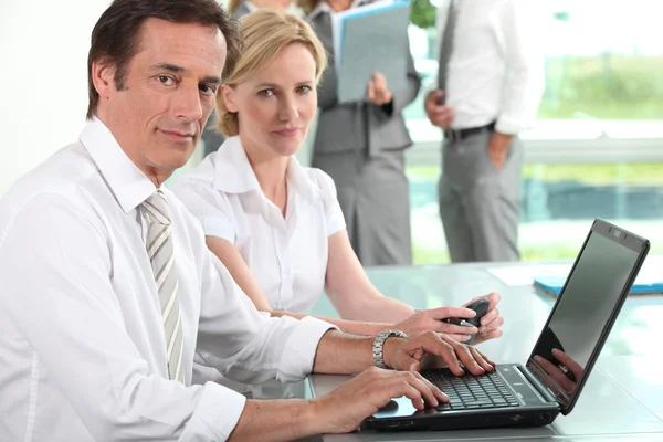 Podnikatel a žena na laptop — Stock fotografie