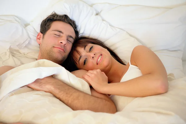 Ευτυχισμένο ζευγάρι ξαπλωμένη στο κρεβάτι — Φωτογραφία Αρχείου