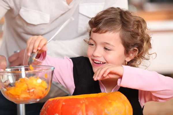 Little girl hollowing out a pumpkin — Stock Photo, Image