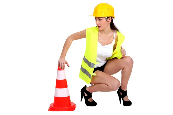 Modelo atraente ajoelhado por cone de tráfego — Fotografia de Stock