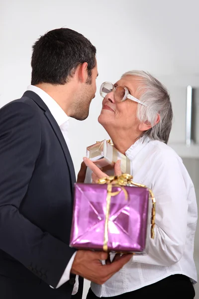 Homem dando presentes de sua mãe — Fotografia de Stock
