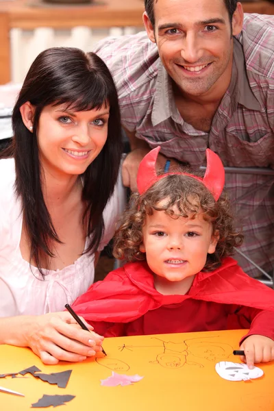 Ouders en een kleine jongen gekleed in duivel — Stockfoto