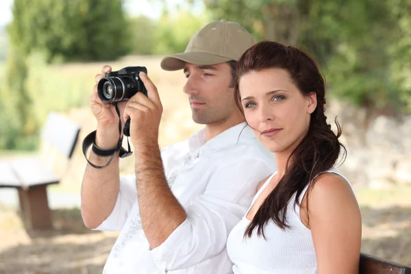 Couple with a camera in the countryside — Stock Photo, Image