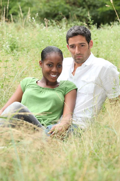 Couple sat in a field — Stock Photo, Image