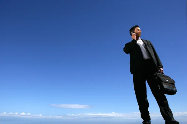 Επιχειρηματίας που στέκεται με ουρανό στο παρασκήνιο — Φωτογραφία Αρχείου