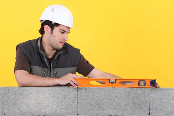 Man with spirit level checking wall — Stock Photo, Image