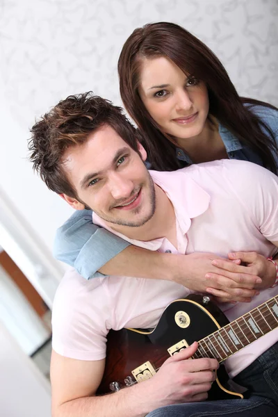 Jonge vrouw en jonge man met gitaar — Stockfoto