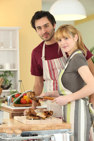 Joven hombre y joven mujer cortando pollo —  Fotos de Stock