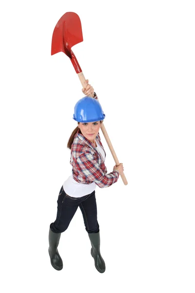 Woman holding spade over head — Stock Photo, Image