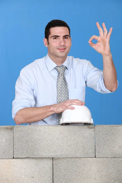 Portrait d'un bel architecte posant près d'un mur de briques inachevé — Photo