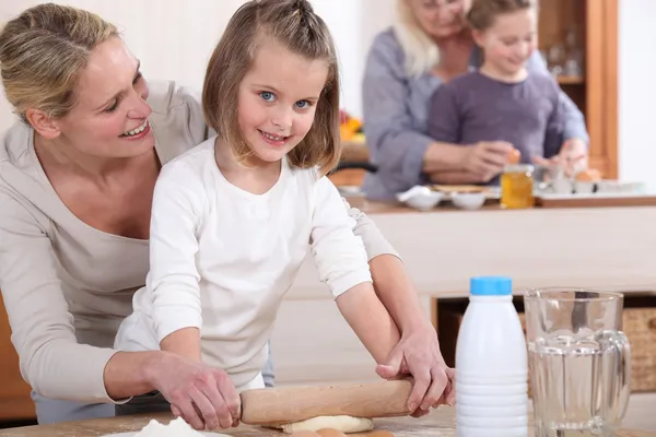 Kleine Mädchen und ihre Mütter backen Kuchen — Stockfoto