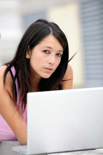 Hübsche junge Frau vor Laptop gelegt — Stockfoto