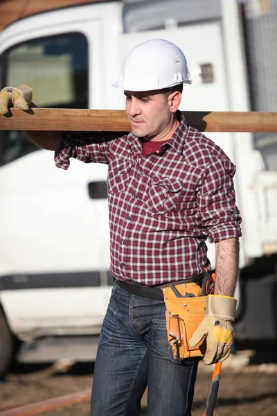 stock image Woodworker carrying a timber