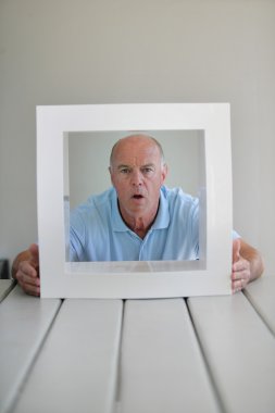 A surprised elderly man framed by a square clipart
