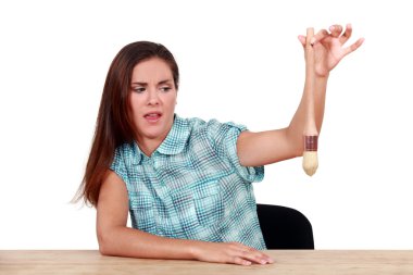Disgusted woman holding a paintbrush clipart