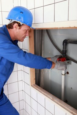 Plumber tightening a pipe clipart