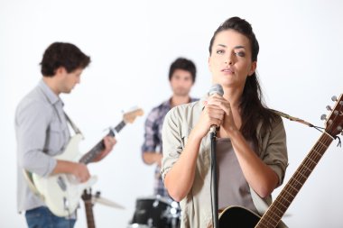 A guitar player, a drummer and a female singer clipart