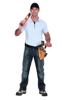 Builder holding spirit level and hammer clipart