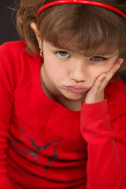 A little girl pouting. clipart