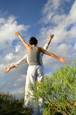 Couple practising yoga outside clipart