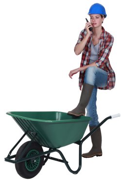 Woman stood with empty wheelbarrow clipart