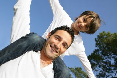 Boy on his father's shoulders clipart