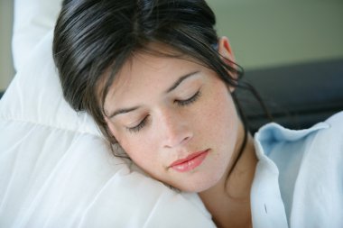 Young woman resting on a sofa clipart