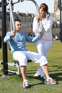 Couple doing gymnastics outdoors clipart