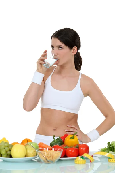 Mujer vestida con ropa deportiva junto a las verduras —  Fotos de Stock