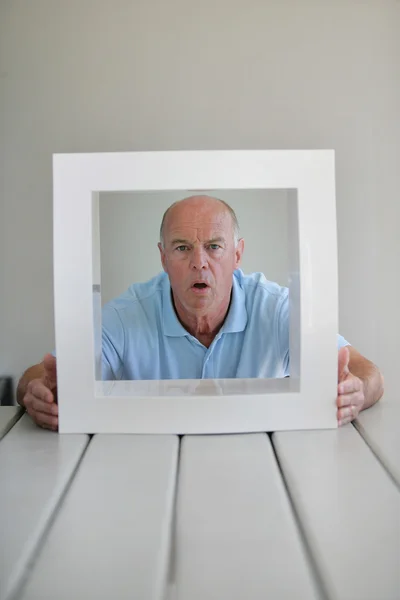 En förvånad äldre man som inramas av en kvadrat — Stockfoto