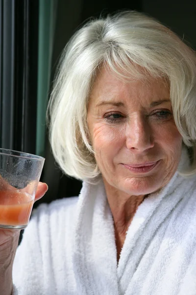 Äldre dam dricka fruktjuice — Stockfoto