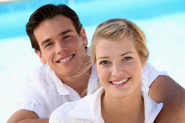 Sorrindo jovem casal com um fundo céu azul — Fotografia de Stock